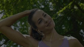 woman stretching neck in park listening with earbuds, showcasing biotech DNA helix overlay. Fitness, wellness, natural, futuristic, vitality, technology, outdoor - Powered by Shutterstock - Get 15% off with code: PIKWIZARD15