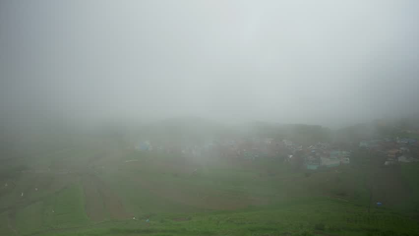 Traditional rural village Poombarai covered in clouds in Kodai hills