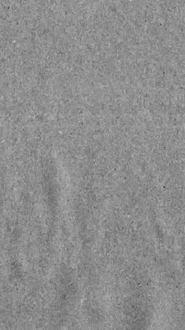 Grey kraft paper noise texture vertical stop motion video. Old page overlay effect background loop animation. Vintage paper texture with crease, stain, grain, dust particles. Empty animated backdrop 