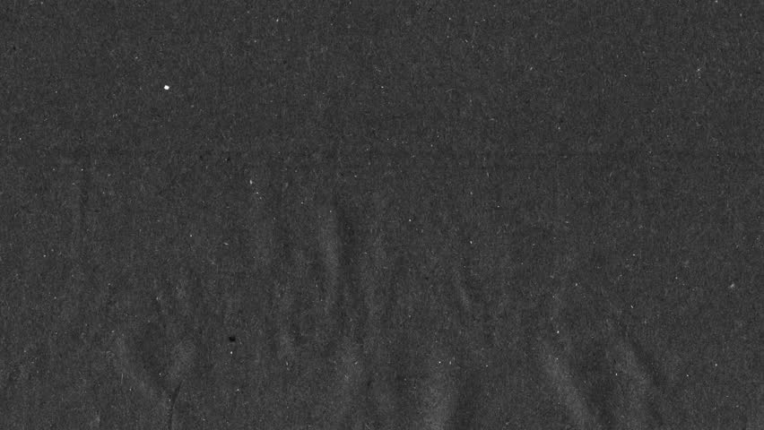 Black kraft paper noise texture 4K stop motion video. Aged old page overlay effect background loop animation. Vintage paper texture with crease, stain, grain, dust particles. Empty animated backdrop 