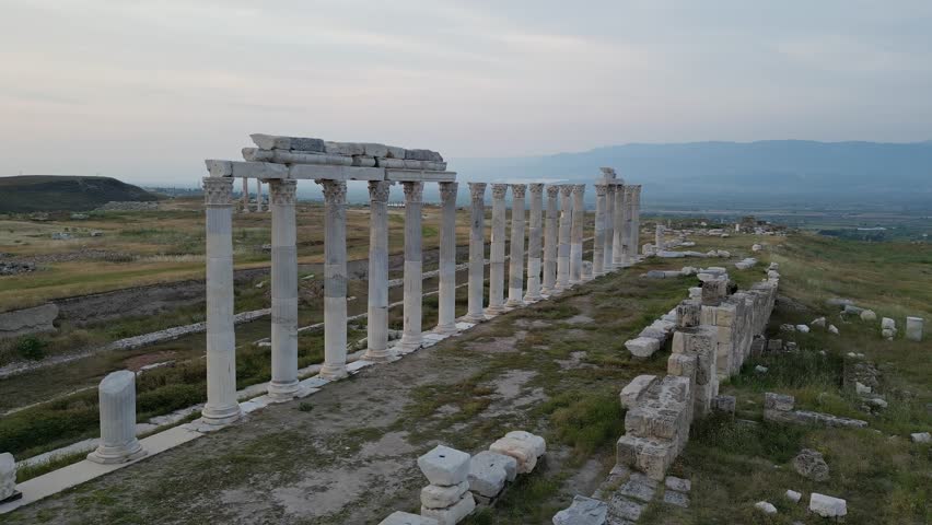 Ruins of Laodicea with marble columns in Turkey Turkiye Turkiye. Aerial view of curved colonnade line. Ancient Roman site in open landscape. Famous archaeological site of Roman Empire