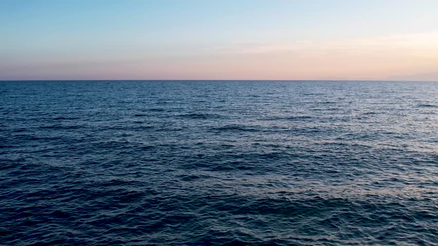 Moving Left Over Calm Sea at Sunset