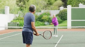 Senior couple playing tennis for health, featuring red W O graphic grid and orange bar overlay. Athletic, wellness, active, outdoor, fitness, recreation, vibrant - Powered by Shutterstock - Get 15% off with code: PIKWIZARD15