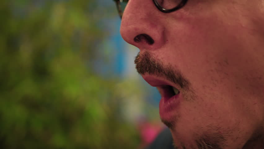 Man Biting And Chewing Octopus During Dinner At The Beach Resort 