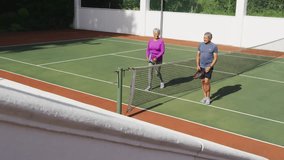 Senior tennis duo giving high-five at net, showing neon HIGH SCORE overlay serving sports marketing. Senior, friendship, competition, outdoor, active, vibrant, motivation - Powered by Shutterstock - Get 15% off with code: PIKWIZARD15