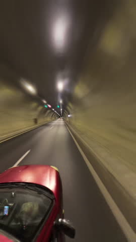 Vertical video. Red Car Driving Through a Tunnel With Motion Blur Effect Creating a Sense of Speed and Acceleration time laps