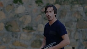 Man holding tennis racket reaching toward neon energy trails against wall, showcasing technology. Sports, athletic, motion, vibrant, dynamic, outdoor, modern - Powered by Shutterstock - Get 15% off with code: PIKWIZARD15