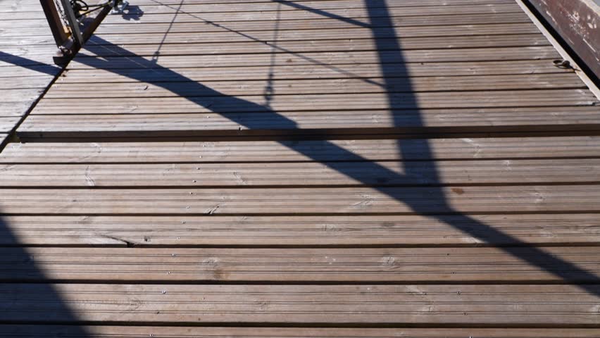 Moving footage of a wooden boat dock on a rural lake in Estonia, Harjumaa, Europe, Baltics in 4k. Summer time and water is beautiful blue with some wind, trees and shores are visible in the background