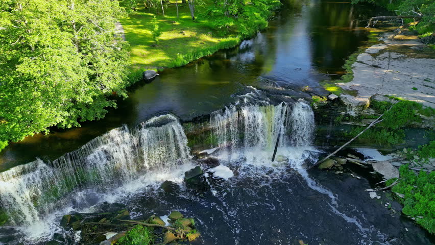 Keila waterfall in a park on a sunny day slowmotion from above pedestral shot