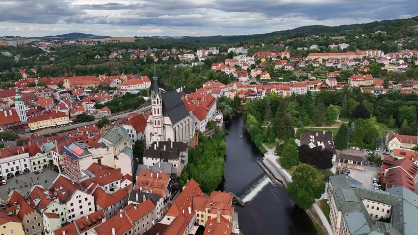 Český Krumlov, South Bohemia, Czechia, July 2023. Drone pushes forward above Vlatava river and St. Jost Church to establish classic medieval architecture of the town.