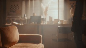 Young man walking into softly lit living room with sunlight streaming through blinds, sitting on couch, leaning back and gazing upward in deep thought - Powered by Shutterstock - Get 15% off with code: PIKWIZARD15