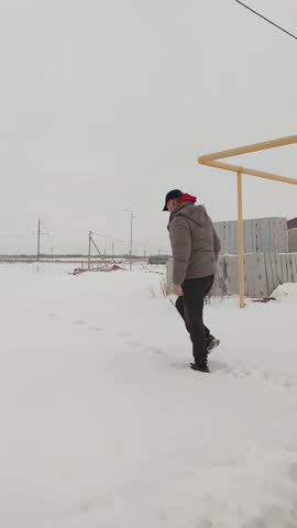 A man walks through the snow in the cold winter