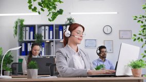 call center young woman in glasses with headset works in international technical support company answers customer calls via video link using computer in office - Powered by Shutterstock - Get 15% off with code: PIKWIZARD15