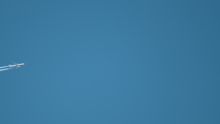 Majestic airplane gliding through the clear blue sky with vibrant contrails