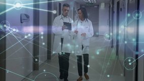 Two doctors walking hospital hall, checking patient data on tablet with network graphic floating. Medical, healthcare, digital, modern, collaboration, technology, professionalism - Powered by Shutterstock - Get 15% off with code: PIKWIZARD15