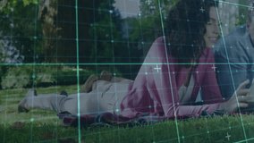 Couple lying on picnic blanket in park, viewing tablet technology with animated data charts. Outdoor, leisure, relaxation, technology, nature, communication, casual - Powered by Shutterstock - Get 15% off with code: PIKWIZARD15