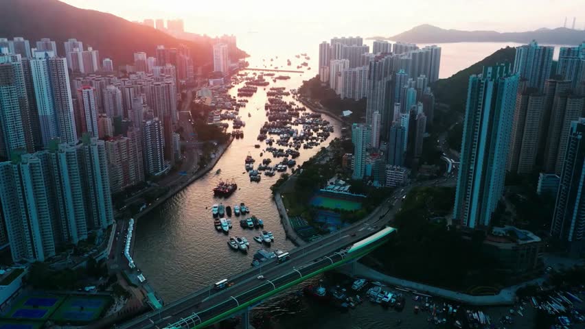 Aerial View of Hong Kong Harbor at Sunset with Boats and Buildings