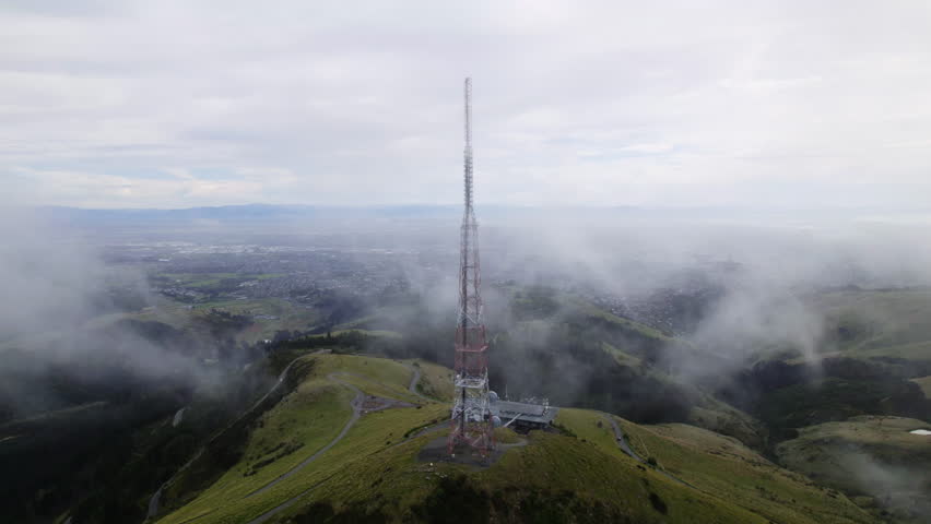 Aerial view circling the radio tower on top of Sugarloaf mountain in New Zealand