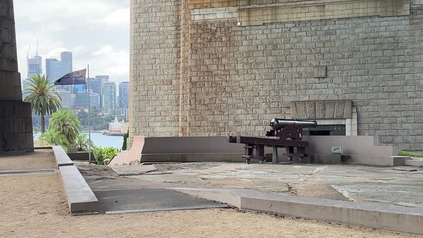 Canon under Sydney Harbour Bridge stone pylon overlooking Port Jackson Australia