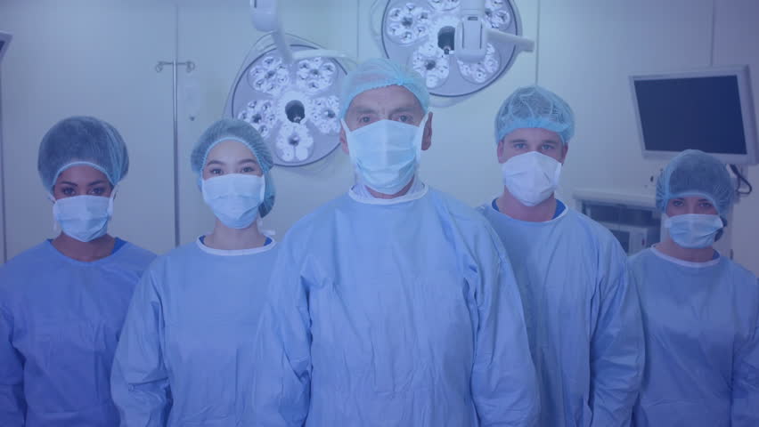 Medical team standing in operating room under surgical lights, displaying animated waveform overlay. Health, teamwork, innovation, diagnostics, professionalism, healthcare, precision - Powered by Shutterstock - Get 15% off with code: PIKWIZARD15