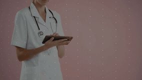 Stethoscope-wearing medical professional using tablet in clinic, showing live icon network overlay. Technology, telemedicine, healthcare, digital, connectivity, innovation, professionalism - Powered by Shutterstock - Get 15% off with code: PIKWIZARD15