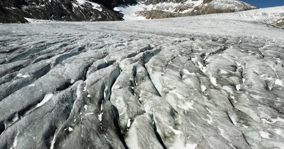Cinematic glacier close-up in the Swiss Alps showing deep cracks in melting ice. A powerful visual of global warming and nature’s raw beauty in the heart of the mountains.