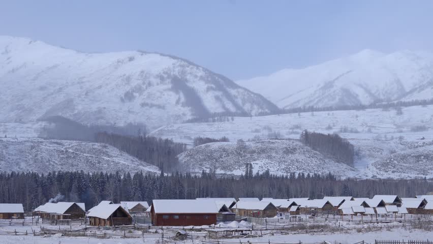 Explore Harbin Northeast Winter Snow Village in a serene winter landscape with picturesque cabins and breathtaking mountains