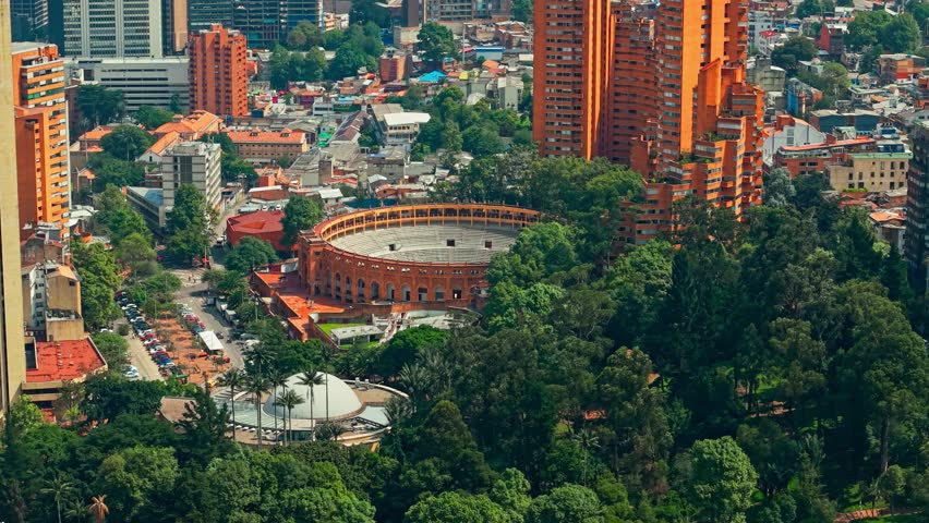 Telephoto aerial view of La Santamaria Bullring with the Planetarium on the side at the bicentennial independence park in Bogota, Colombia on a sunny day.