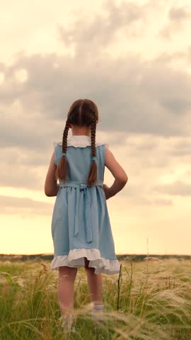 Child Girl playing in meadow. Cute little girl running on summer field with sky enjoy freedom happy childhood. Elegant female kid child run at meadow green grass nature landscape, back view, slowmo.