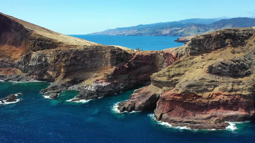 Spectacular coastal cliffs and azure sea at beautiful seaside location under blue sky