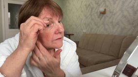 Senior woman plucking her eyebrows - Powered by Shutterstock - Get 15% off with code: PIKWIZARD15