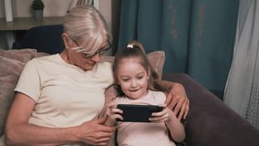 Grandmother and granddaughter learning together using a smartphone, highlighting family bonding through modern technology. - Powered by Shutterstock - Get 15% off with code: PIKWIZARD15