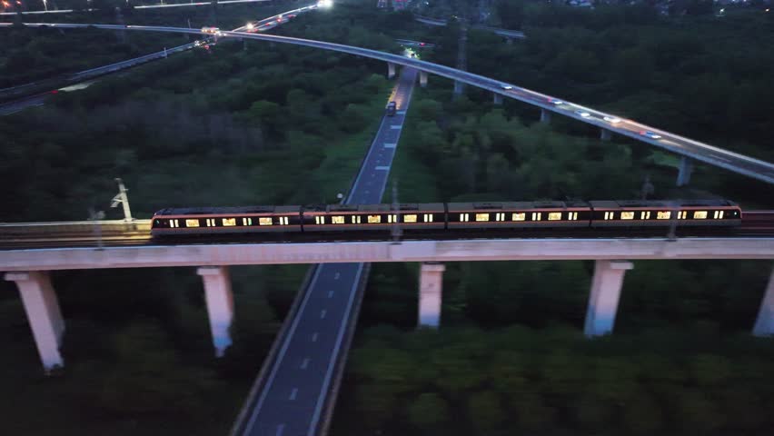 Explore aerial views of intercity light rail trains traveling through urban landscapes at night
