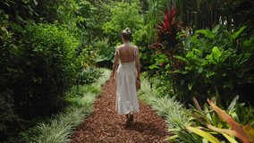 A young, beautiful tourist woman walks through Sydney's Royal Botanic Garden on a bright summer day. Lush greenery, exotic flowers and tropical plants surround her in this vibrant nature setting. - Powered by Shutterstock - Get 15% off with code: PIKWIZARD15