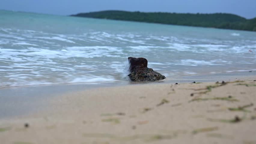 The stormy waves washing the beach with a rock before Hurricane Dorian in Puerto Rico