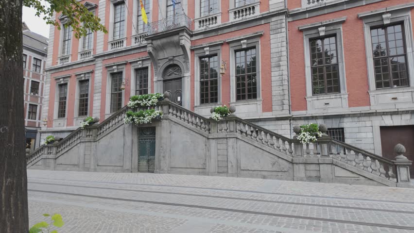 Elegant historic city hall in Liège with symmetrical staircases and vibrant flower arrangements