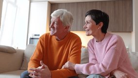 Loving joyful senior couple talking, dreaming, looking at window, together on sofa, joking around. Comfort trust, love connection, bonding over shared moment, positive mood, support in relationship - Powered by Shutterstock - Get 15% off with code: PIKWIZARD15