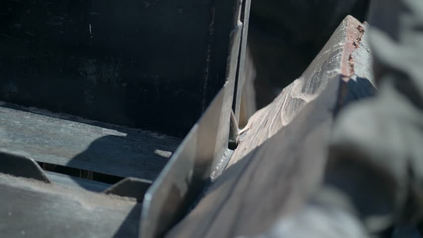 Man who works as a joiner pulling planks out of a log in his mobile sawmill