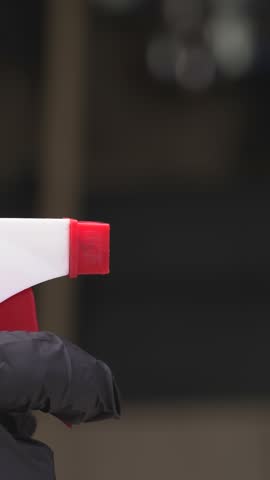 man in black gloves spraying liquid from a spray bottle
