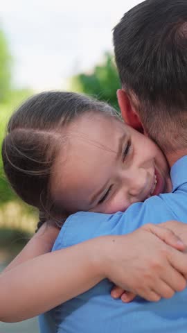 Family hugs. Child daughter, hugging father in spring park outdoors. Close up. Happy family. Carefree childhood happy emotions of baby daddy. Little kid having fun play outdoors with parent in summer