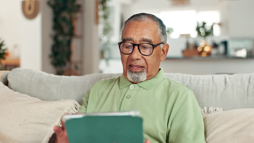 Senior, man and scroll with tablet on sofa for web surfing, playing online games and reading ebook. Retirement, elderly person and happy with digital app in home with streaming subscription and relax