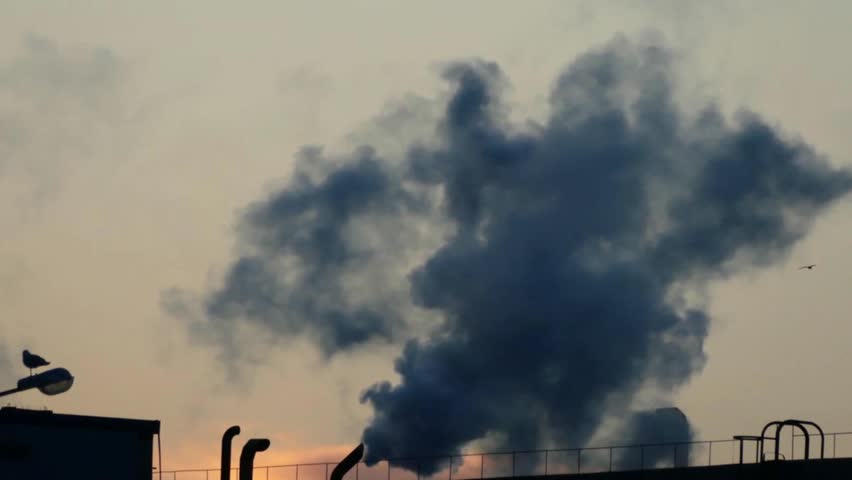 Air pollution: dark smoke rises into the atmosphere.