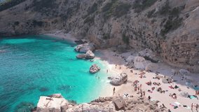 Aerial drone view on white sand Cala Baunei in Orosei Gulf of Sardegna. Warm turquoise sea and small beach surrounded with green mountains on the Sardinia island. - Powered by Shutterstock - Get 15% off with code: PIKWIZARD15