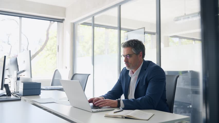 Mature 50s Latin business man ceo manager using laptop computer in office. Focused senior businessman entrepreneur sitting at desk working on financial project, typing looking at screen. Copy space - Powered by Shutterstock - Get 15% off with code: PIKWIZARD15