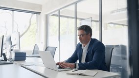 Mature 50s Latin business man ceo manager using laptop computer in office. Focused senior businessman entrepreneur sitting at desk working on financial project, typing looking at screen. Copy space - Powered by Shutterstock - Get 15% off with code: PIKWIZARD15