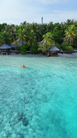 woman in a bikini relaxes on a yellow kayak floating on clear turquoise sea, top-down view from above, peaceful moment in tropical paradise, summer holiday, maldives, travel, holidays, vacation