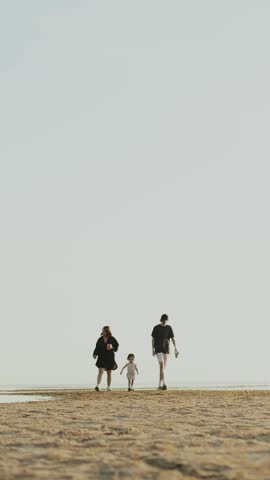 A Family Enjoys a Lovely Stroll Along a Beautiful Scenic Beach During Dusk Hours