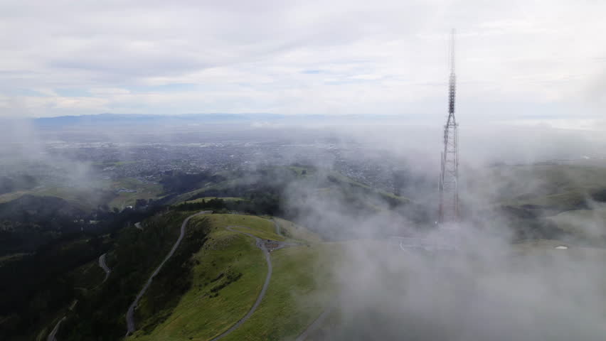 Aerial view of clouds moving over Sugarloaf mountain in gloomy New Zealand