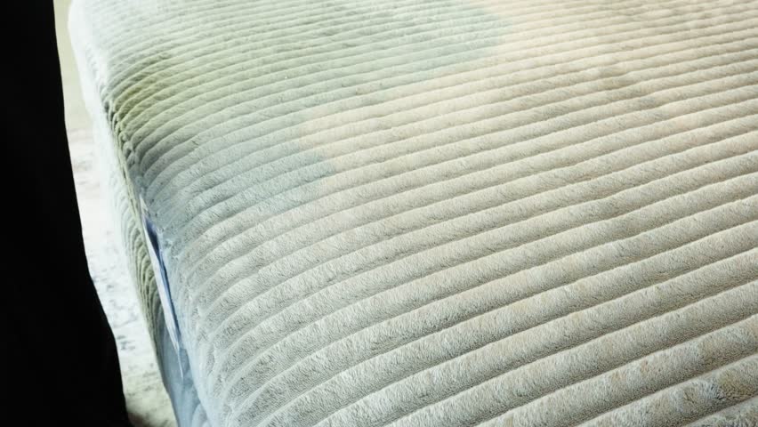 Gentle pan shows hand caressing light green raised upholstery texture