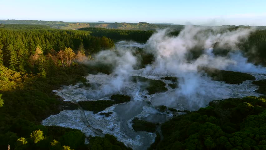 Steam escaping in the middle of a geothermal valley, Drone slowly flying over geothermal landscape. Trees, steam, bubbling mud and steam. Alien Landscape. Sci-fi. Global Warming